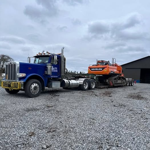 Craft Tree & Land Clearing equipment truck hauling an excavator